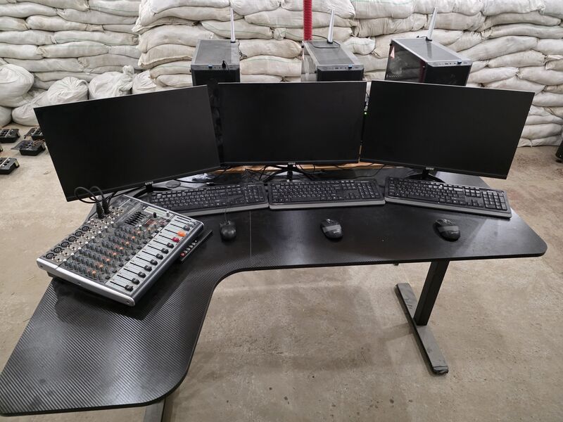 Operator control station with three monitors, audio mixer, and compute units